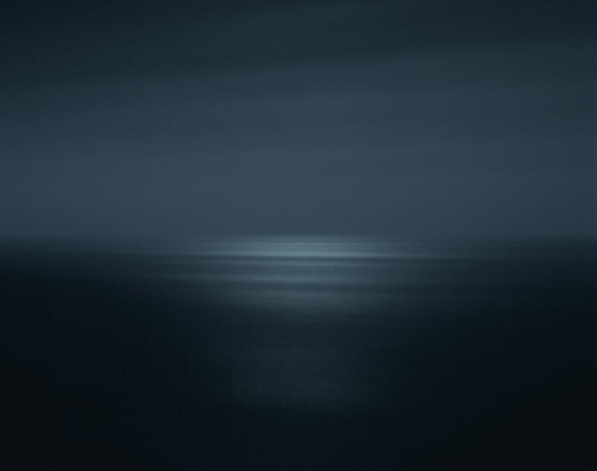 Photograph with lines of grey and blue giving the impression of an ocean leading out to a horizon
