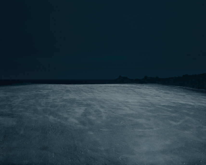 Photograph of a landscape in greys and blues, a horizon visible in the background