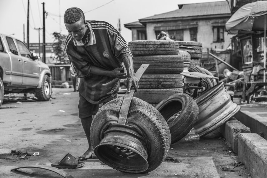 A vulcanizer in the Mushin neighborhood of Lagos uses the mount/demount iron tool to remove a faulty tire for repair.