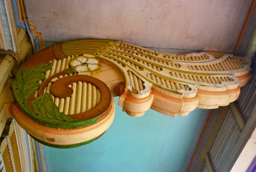 Photograph of intricate carving under rafter of a house.