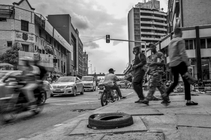 Photograph of a city street with a tire foregrounded
