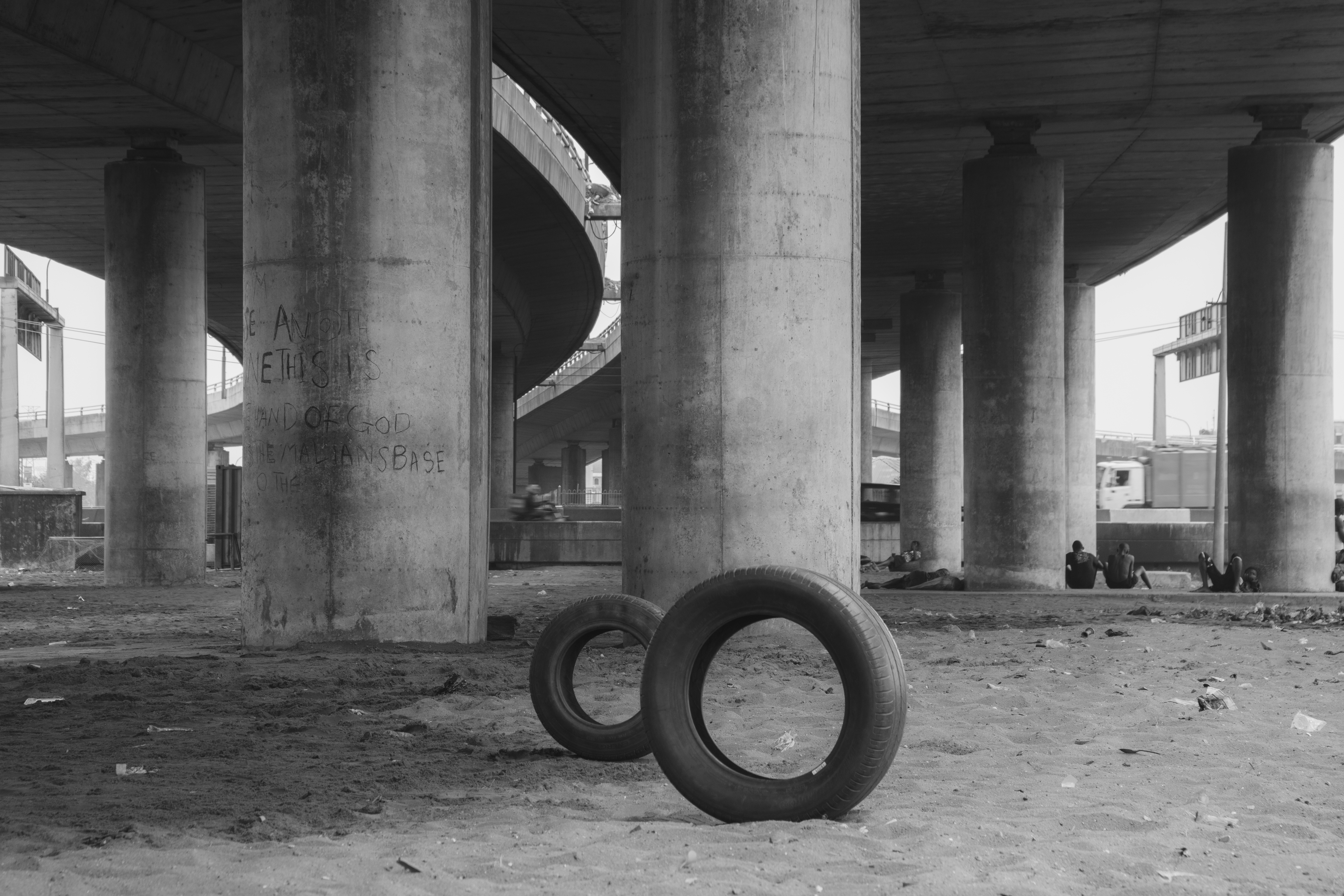 Photograph of two upright tires under an overpass