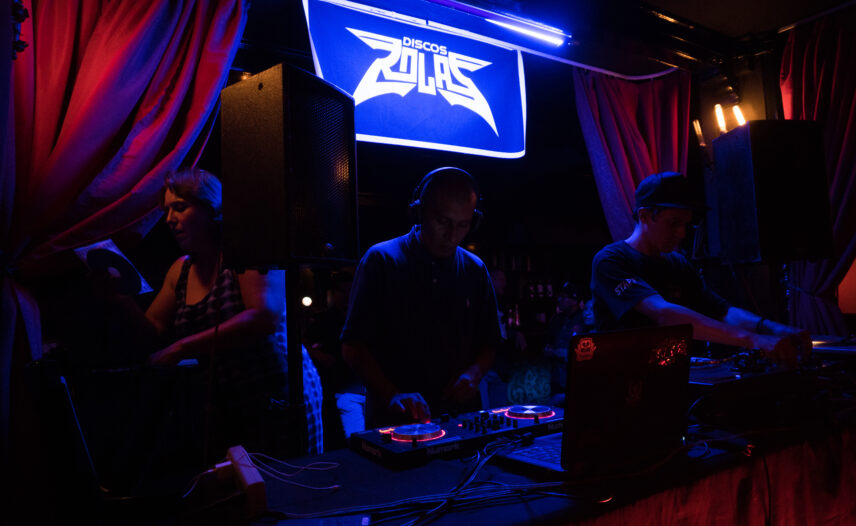Photograph of three people in low light
