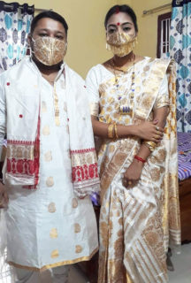 Photograph of a masked bridal couple.
