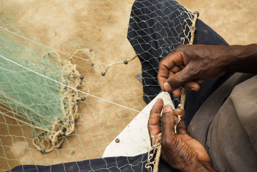 A picture of a man repairing his cast net