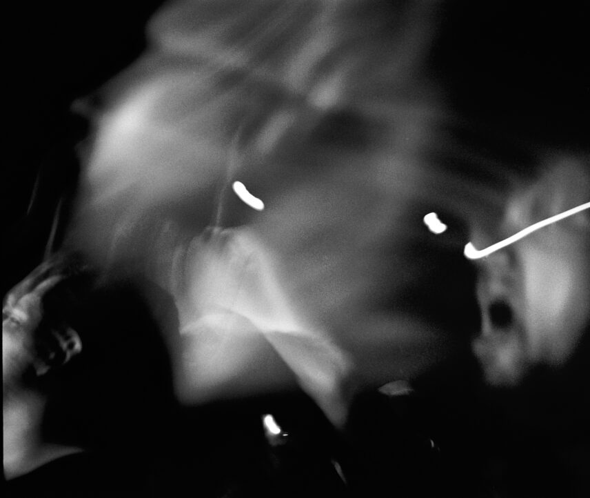 Blurry black and white photograph of a mosh pit