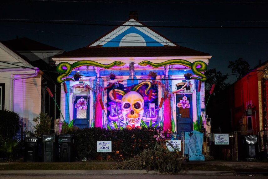 Photograph of a housefront at night, a mural on its front well-lit