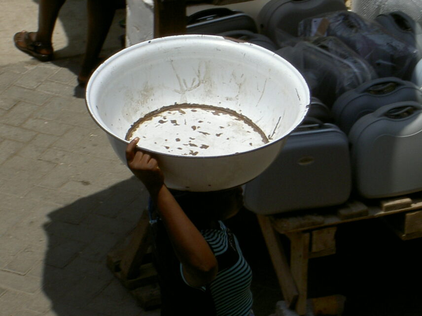 A market women balances an empty bowl in her head