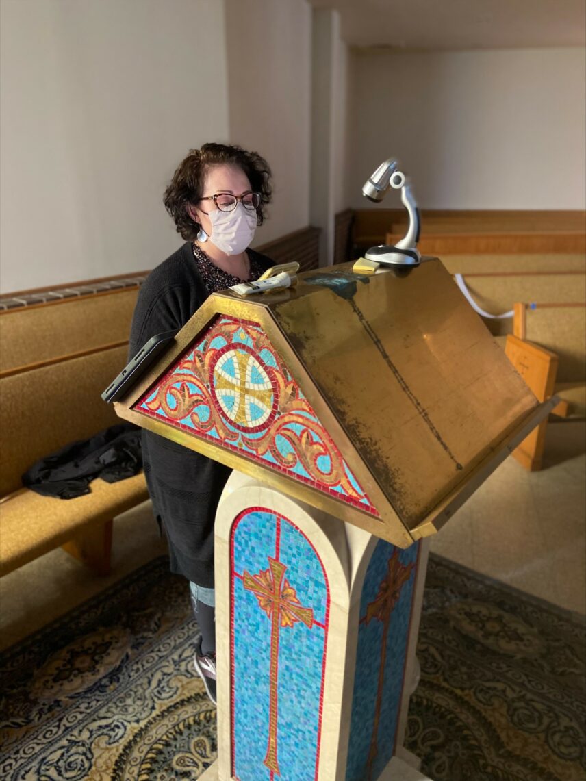 A photograph of a woman standing behind the lectern