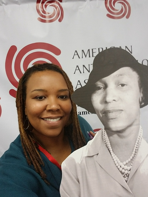 The author stands by a cardboard cut-out of Zora Neale Hurston