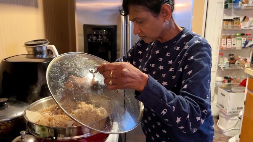 Kala making puttu, a dish made of rice flour and fresh coconut that is layered and steamed in a cylinder-shaped mold.