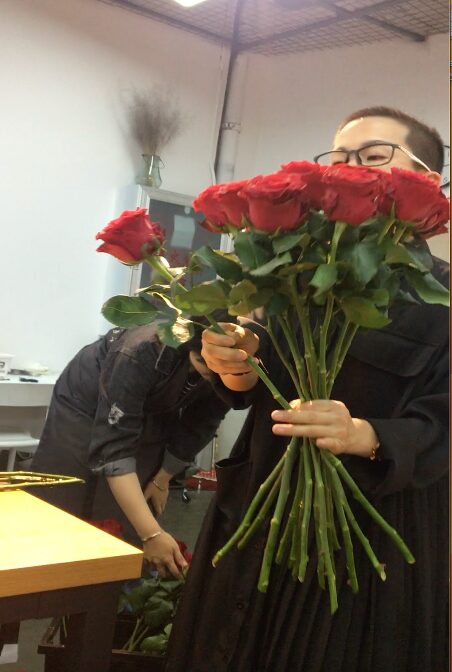 In a florist training session, the instructor was demonstrating a “good clench” for the arrangement of hand-tied red-rose bouquet.