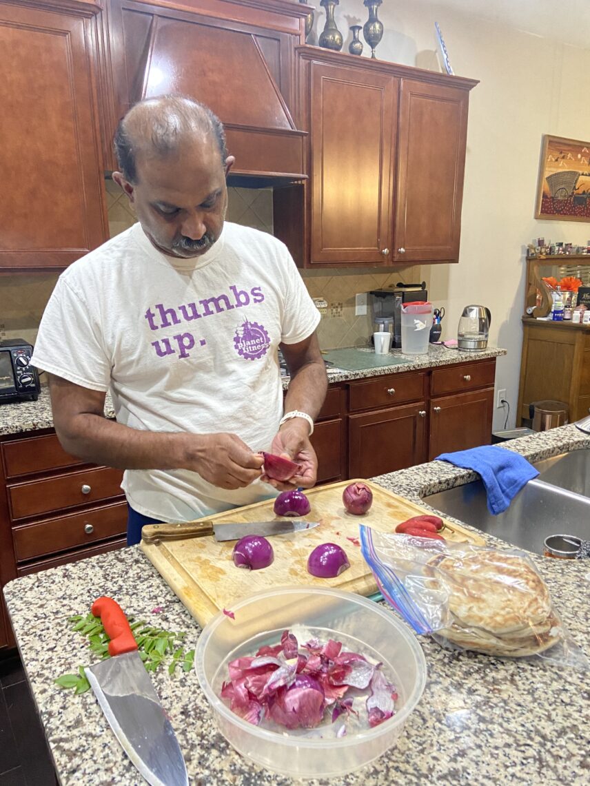 Thushy peels red onion for his mutton kothu roti, a dish made of chopped flatbread mixed and mashed together with mutton curry, vegetables, and eggs.
